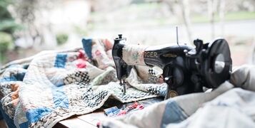 Antique,Black,Sewing,Machine,Making,Large,Quilt,With,Needles,In